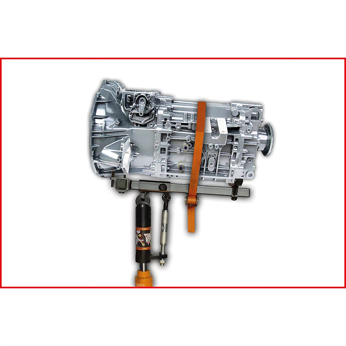 Silbernes Getriebeteil auf einer Hebebühne, mit orangefarbenem Gurt gesichert.